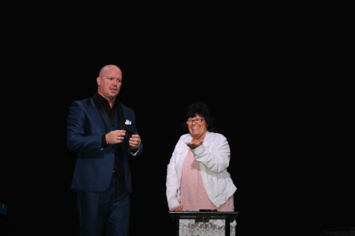 A man asking a woman to come on stage