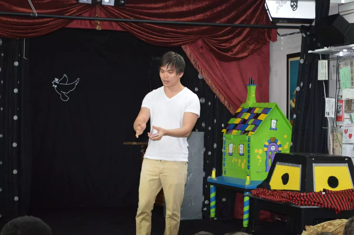 A man standing on stage with a puppet.