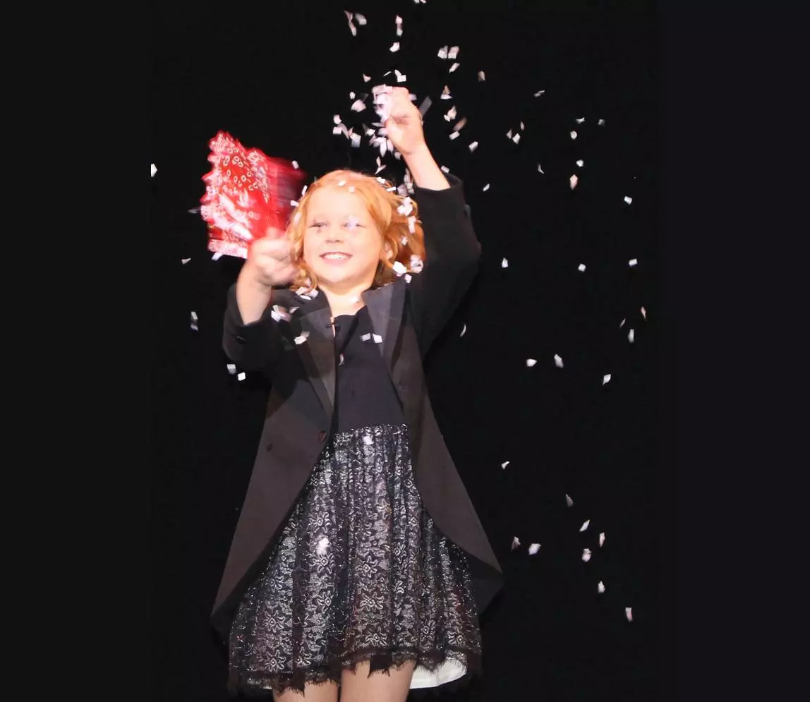 A girl performing magic show on the stage