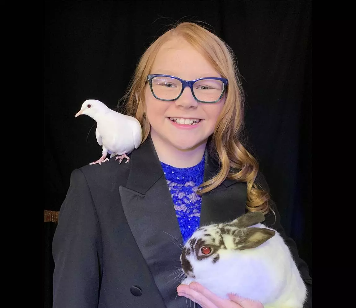 A girl wearing blue eye glasses and smiling