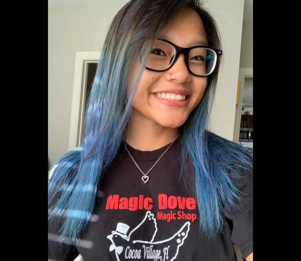 A beautiful woman with blue hair, smiling
