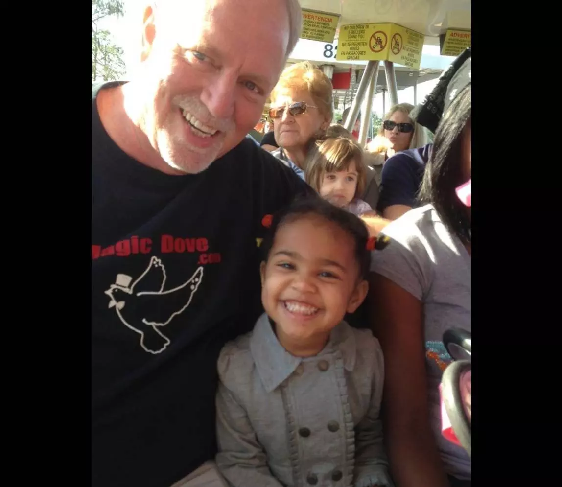 A man smiling with a girl toddler and posing together