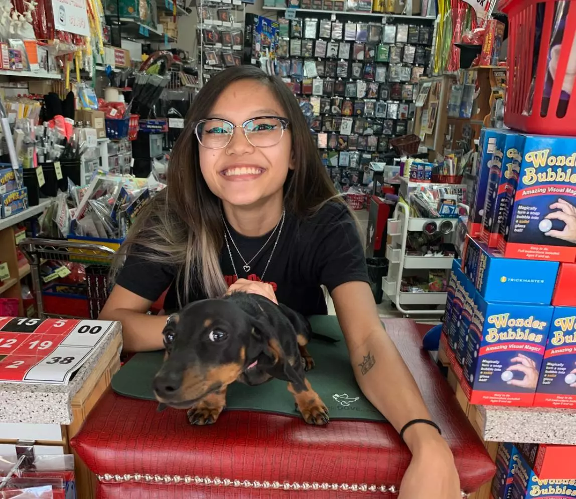 A girl holding a puppy and smiling