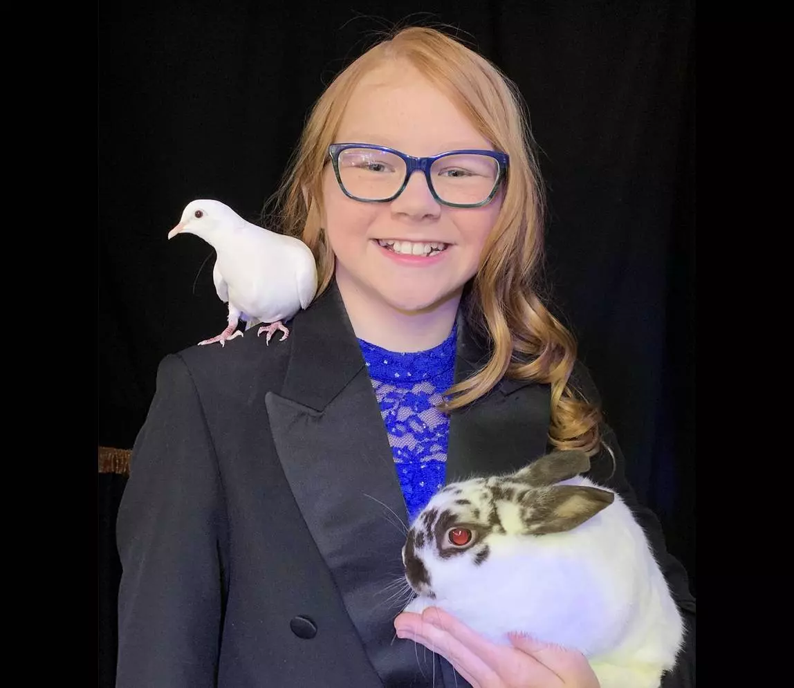 A girl holding a rabbit and smiling