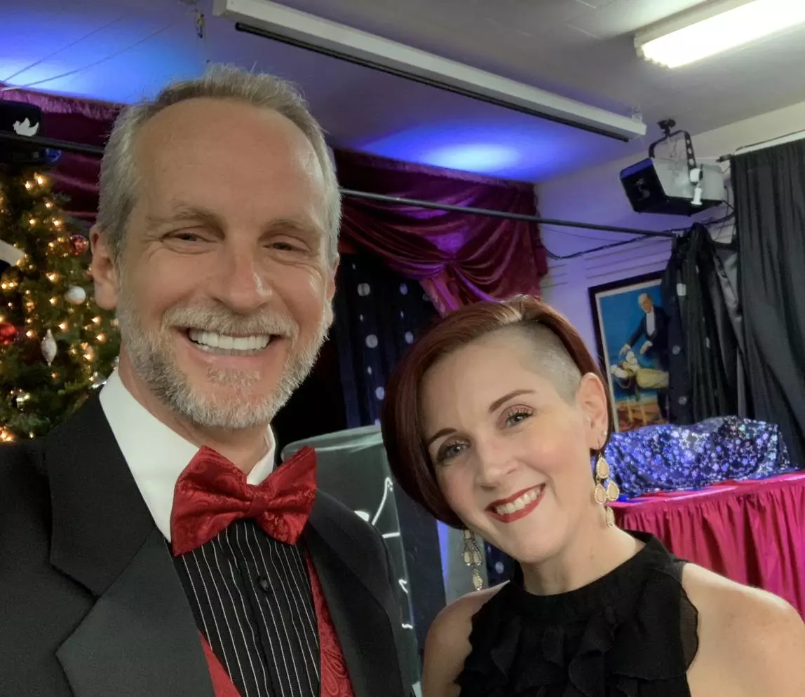 A woman with short hair posing with the magician