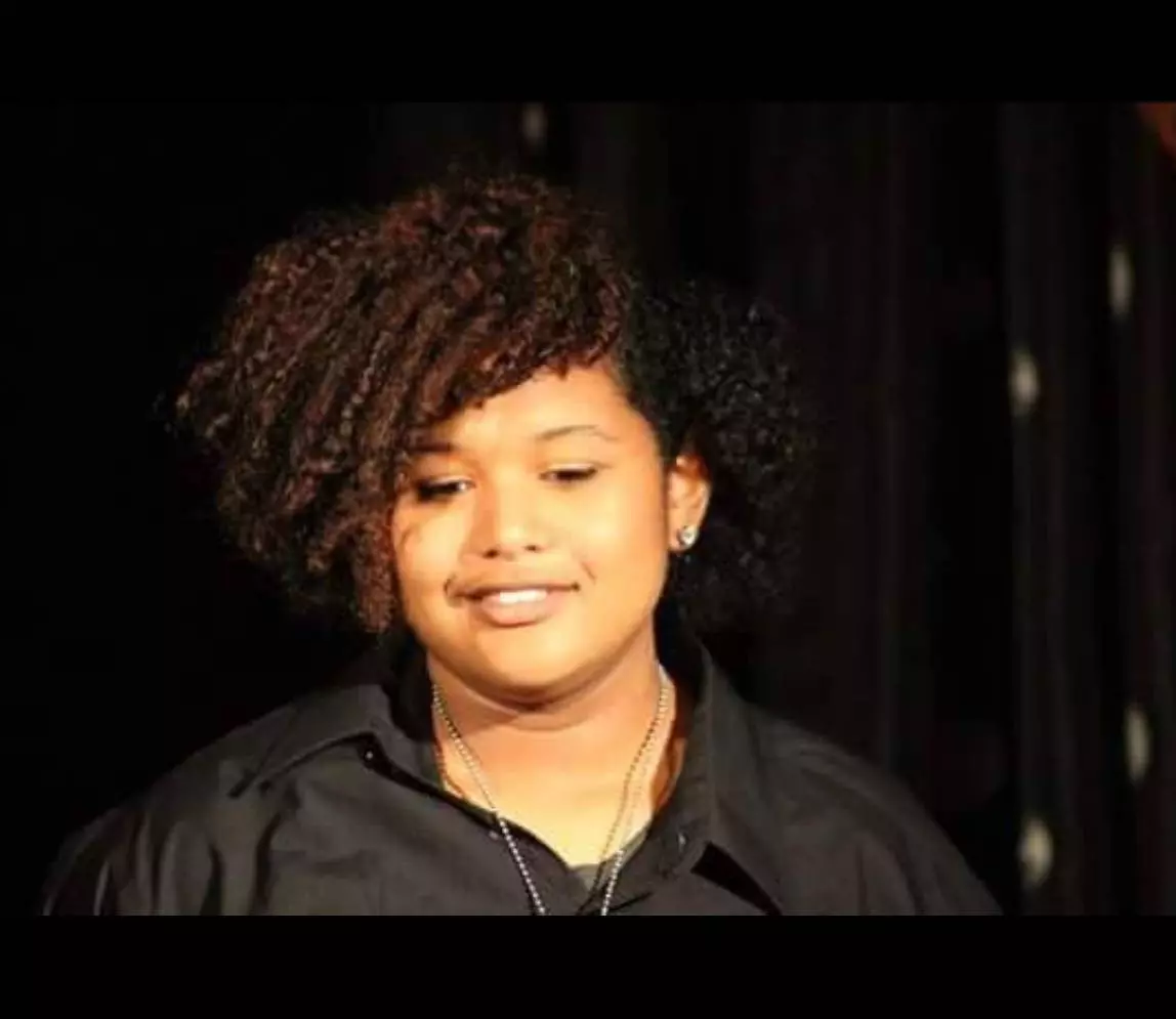 A woman with curly hair and smiling