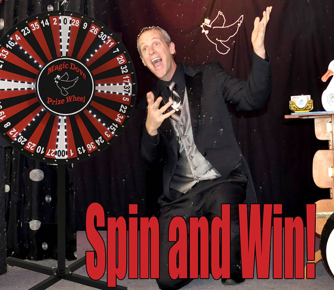 Mr dan with spin and win wheel, wearing a black suit