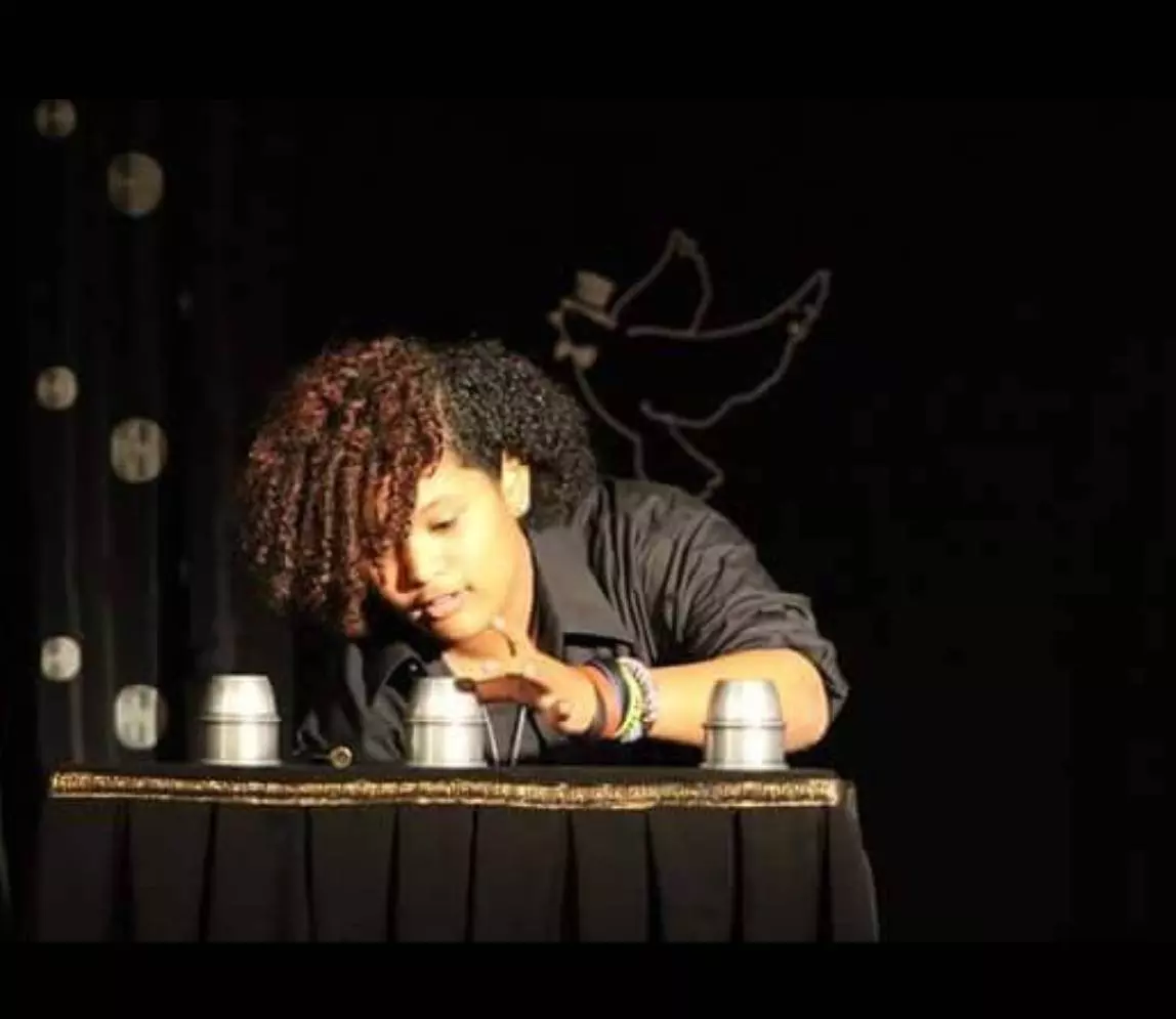 The girl with the curly performing magic trick