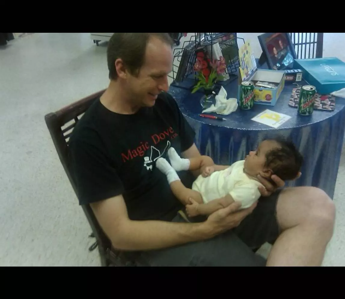 A man holding a baby and smiling