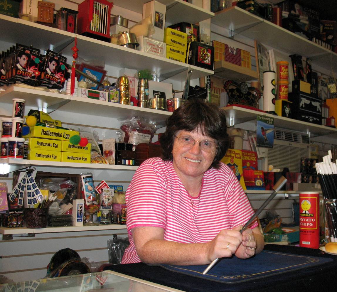 A woman holding a magic wand at a shop