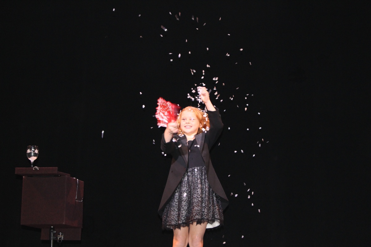 A small girl performing a magic trick