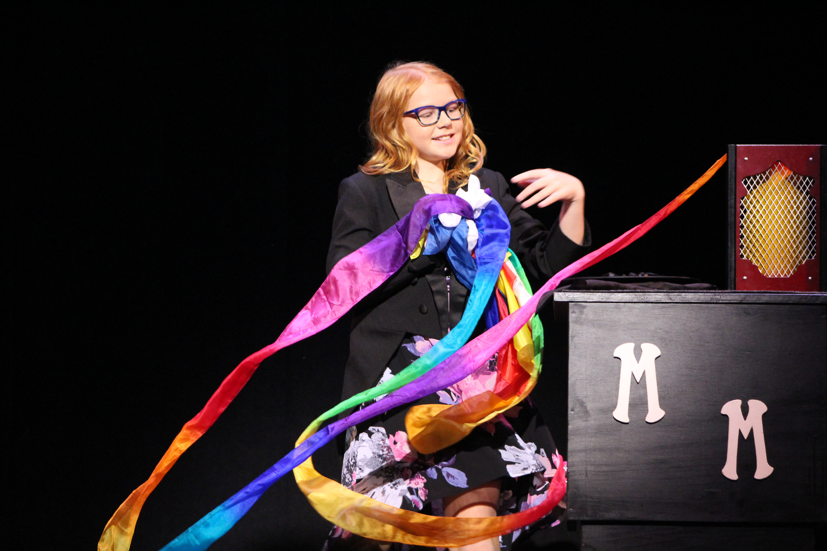 A woman holding a rainbow ribbon.